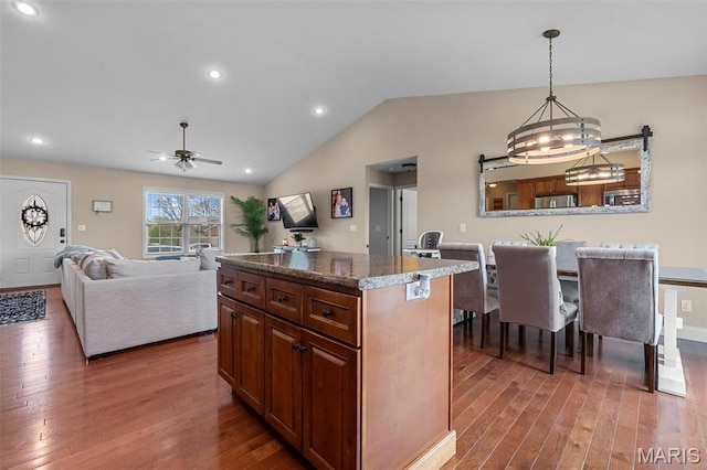 1607 Enterprise Ct, Jackson, MO 63755 - kitchen featuring wood finished floors, ceiling fan, a kitchen island, lofted ceiling, and hanging light fixtures