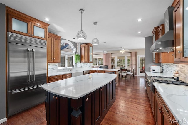 1416 Haarman Oak Dr, Wildwood, MO 63005 - kitchen with stainless steel appliances, wall chimney range hood, decorative backsplash, a peninsula, and recessed lighting