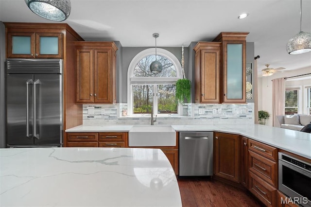 1416 Haarman Oak Dr, Wildwood, MO 63005 - kitchen featuring appliances with stainless steel finishes, tasteful backsplash, light stone counters, brown cabinets, and recessed lighting