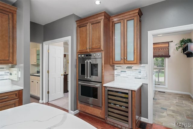 1416 Haarman Oak Dr, Wildwood, MO 63005 - kitchen featuring beverage cooler, stainless steel double oven, brown cabinets, decorative backsplash, and recessed lighting