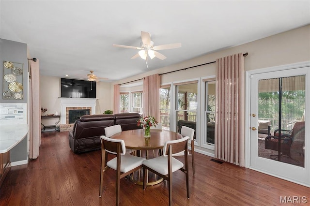 1416 Haarman Oak Dr, Wildwood, MO 63005 - dining space with a ceiling fan, a fireplace, and dark wood-style flooring