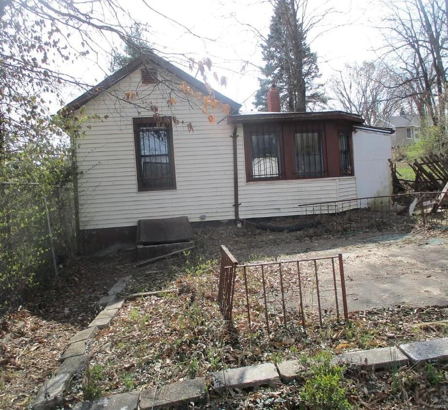 5475 Janet Ave, Saint Louis, MO 63136 - view of side of home with fence and a chimney