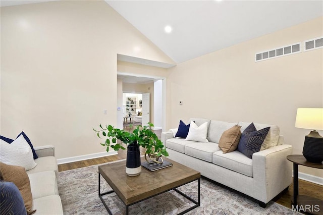 living room with baseboards, wood finished floors, high vaulted ceiling, and recessed lighting