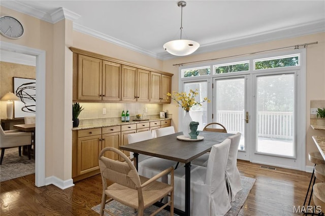 dining room with crown molding and dark wood-style flooring