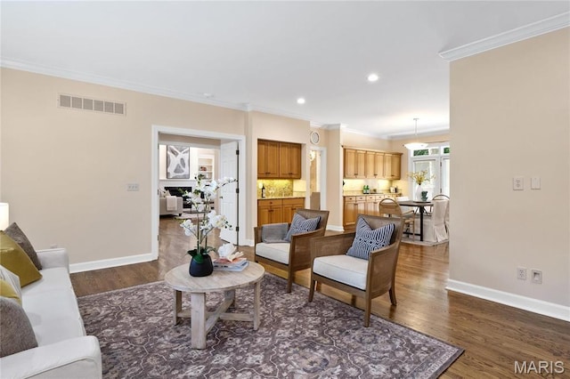 living area with crown molding, dark wood-type flooring, baseboards, and recessed lighting