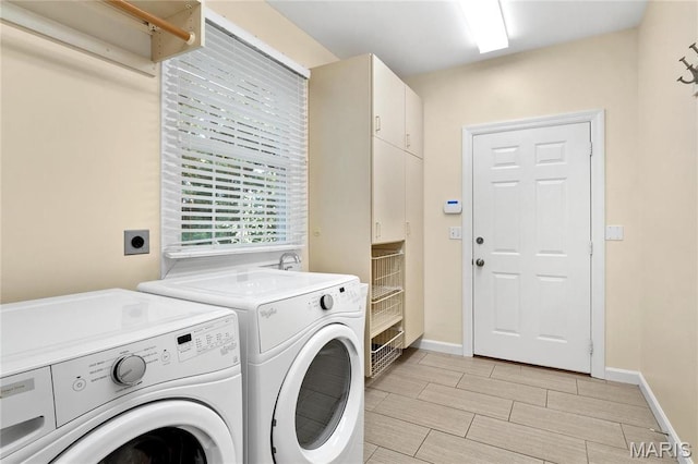clothes washing area with independent washer and dryer, wood finish floors, and baseboards