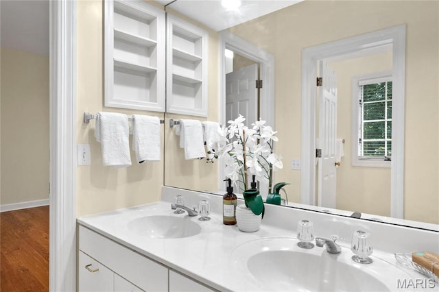 bathroom with wood finished floors and double vanity