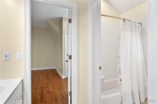 full bath with wood finished floors, lofted ceiling, shower / bath combo with shower curtain, and vanity