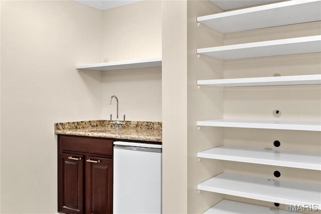 indoor wet bar featuring white dishwasher