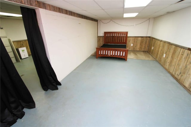 634 Ccam Rose Ln, Perryville, MO 63775 - unfurnished bedroom featuring wood walls, concrete floors, wainscoting, and a paneled ceiling