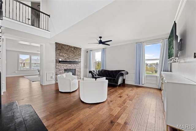 351 Oak Stand Ct, Chesterfield, MO 63005 - living room with wood finished floors, plenty of natural light, a fireplace, a wainscoted wall, and crown molding