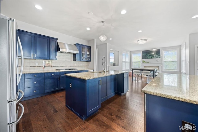 351 Oak Stand Ct, Chesterfield, MO 63005 - kitchen with freestanding refrigerator, a sink, blue cabinets, wall chimney exhaust hood, and dark wood-style floors