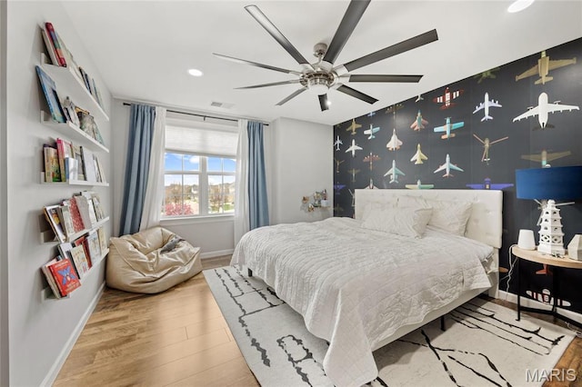 351 Oak Stand Ct, Chesterfield, MO 63005 - bedroom featuring an accent wall, baseboards, wood finished floors, wallpapered walls, and a ceiling fan
