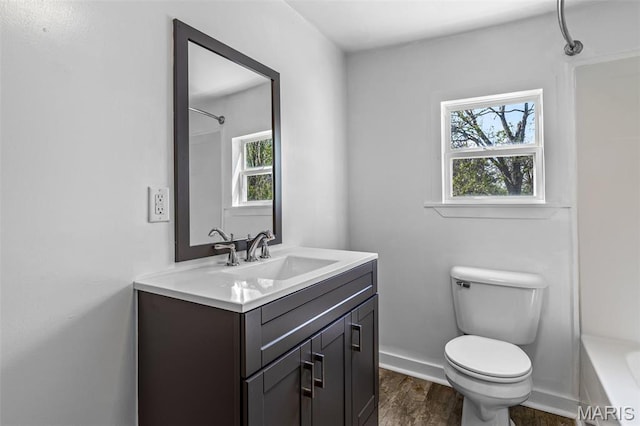 209 N Washington St, Desloge, MO 63601 - bathroom with toilet, vanity, wood finished floors, shower / washtub combination, and baseboards