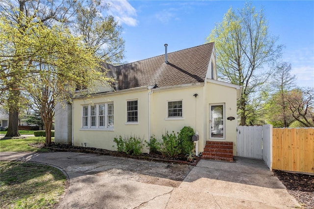 669 Park Ave, Sikeston, MO 63801 - view of front of house with stucco siding, a shingled roof, and fence
