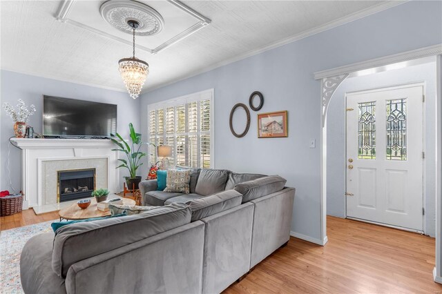 669 Park Ave, Sikeston, MO 63801 - living area with light wood-style flooring, a chandelier, crown molding, a fireplace, and baseboards