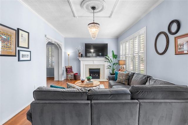 669 Park Ave, Sikeston, MO 63801 - living area with plenty of natural light, wood finished floors, a chandelier, a fireplace with flush hearth, and ornamental molding