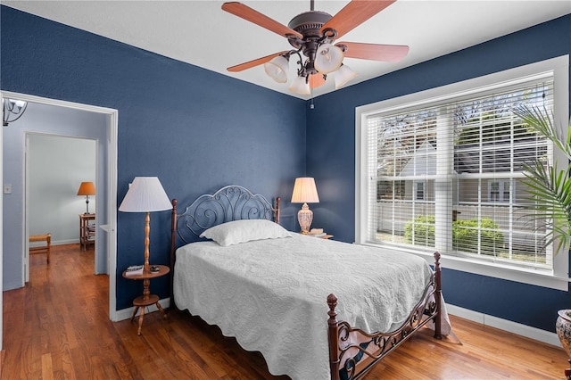 669 Park Ave, Sikeston, MO 63801 - bedroom featuring multiple windows, wood finished floors, baseboards, and ceiling fan