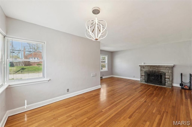 8724 Magdalen Ave, Saint Louis, MO 63144 - unfurnished living room featuring wood finished floors, a chandelier, baseboards, and a fireplace