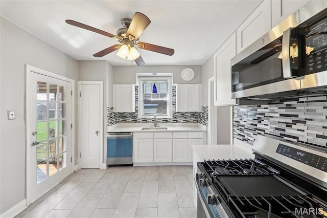 8724 Magdalen Ave, Saint Louis, MO 63144 - kitchen with appliances with stainless steel finishes, decorative backsplash, light countertops, white cabinetry, and a sink