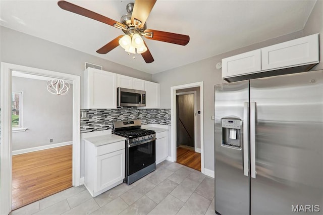 8724 Magdalen Ave, Saint Louis, MO 63144 - kitchen featuring stainless steel appliances, light countertops, white cabinets, ceiling fan, and baseboards