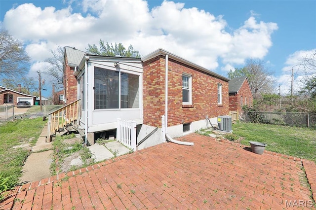 8724 Magdalen Ave, Saint Louis, MO 63144 - back of house featuring fence, a sunroom, brick siding, central AC unit, and a patio area