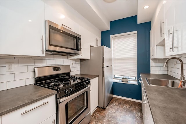 5507 Waterman Blvd Unit C, Saint Louis, MO 63112 - kitchen featuring appliances with stainless steel finishes, a sink, dark countertops, and white cabinetry