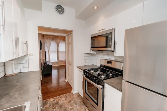 5507 Waterman Blvd Unit C, Saint Louis, MO 63112 - kitchen featuring stainless steel appliances, white cabinets, dark countertops, and tasteful backsplash