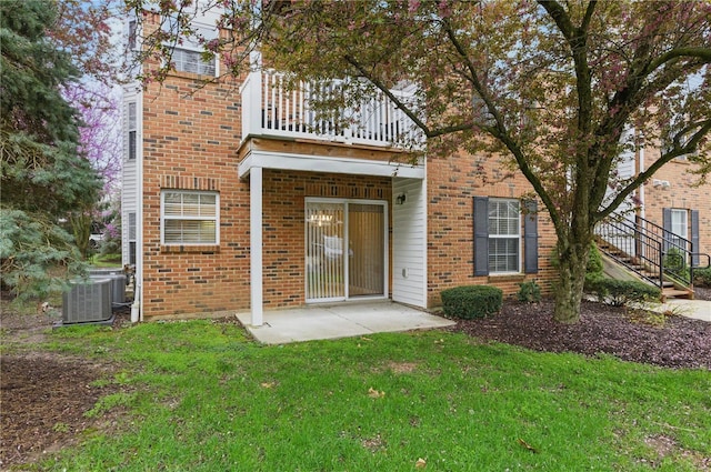 430 Benton Dr Unit C, Saint Peters, MO 63376 - rear view of house featuring a balcony, a lawn, central air condition unit, a patio area, and brick siding