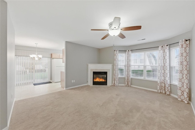 430 Benton Dr Unit C, Saint Peters, MO 63376 - unfurnished living room featuring light colored carpet, a chandelier, a glass covered fireplace, baseboards, and a ceiling fan