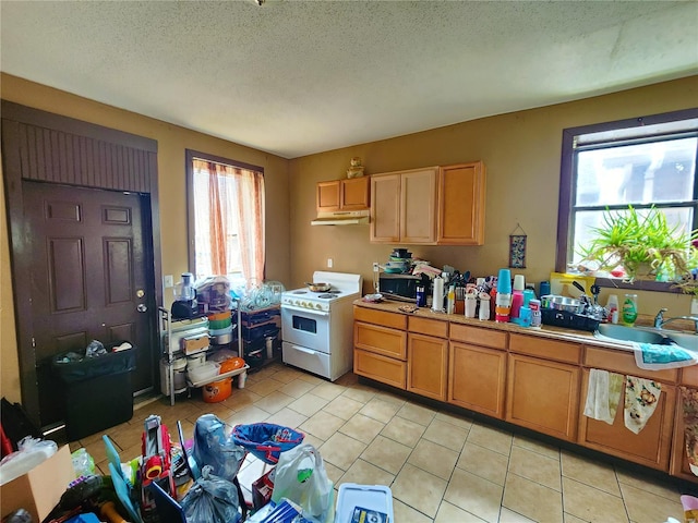 4052 Detonty St, Saint Louis, MO 63110 - kitchen with electric range, under cabinet range hood, light tile patterned flooring, light countertops, and a textured ceiling
