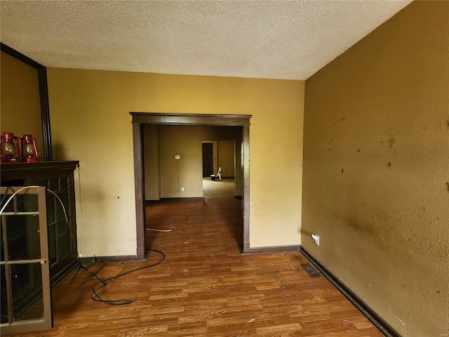 4052 Detonty St, Saint Louis, MO 63110 - hallway with wood finished floors, a textured ceiling, and baseboards