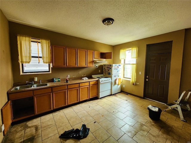 4052 Detonty St, Saint Louis, MO 63110 - kitchen featuring white appliances, brown cabinets, a sink, and a textured ceiling