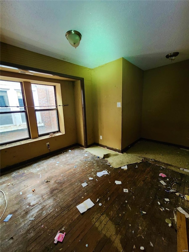 4052 Detonty St, Saint Louis, MO 63110 - empty room featuring baseboards, a textured ceiling, and hardwood / wood-style floors