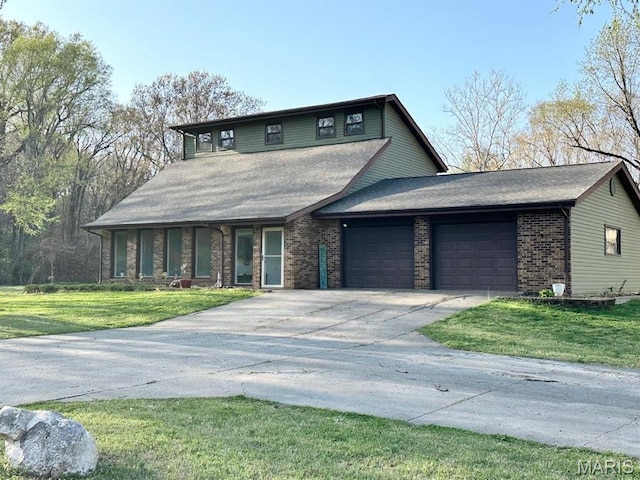 view of front of home featuring a garage, brick siding, a front yard, and driveway