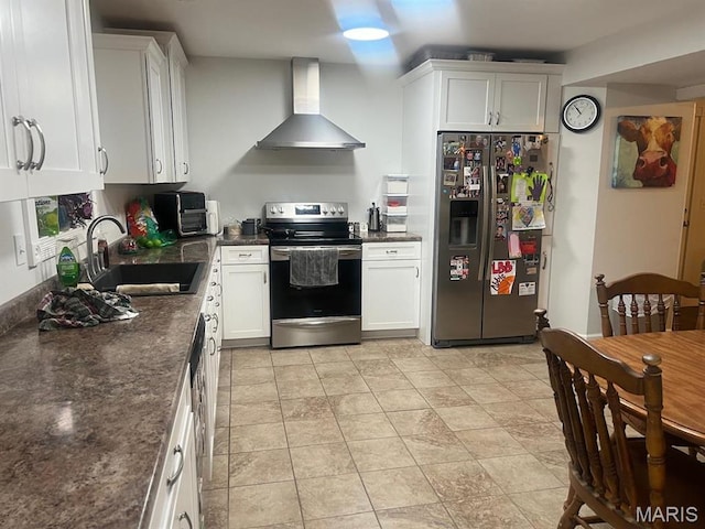 kitchen with stainless steel appliances, wall chimney range hood, a sink, and white cabinetry