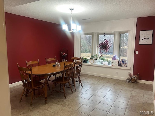 dining room with baseboards, a textured ceiling, and tile patterned flooring