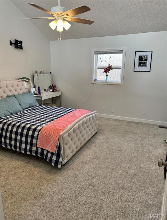 bedroom with baseboards, carpet floors, lofted ceiling, and ceiling fan
