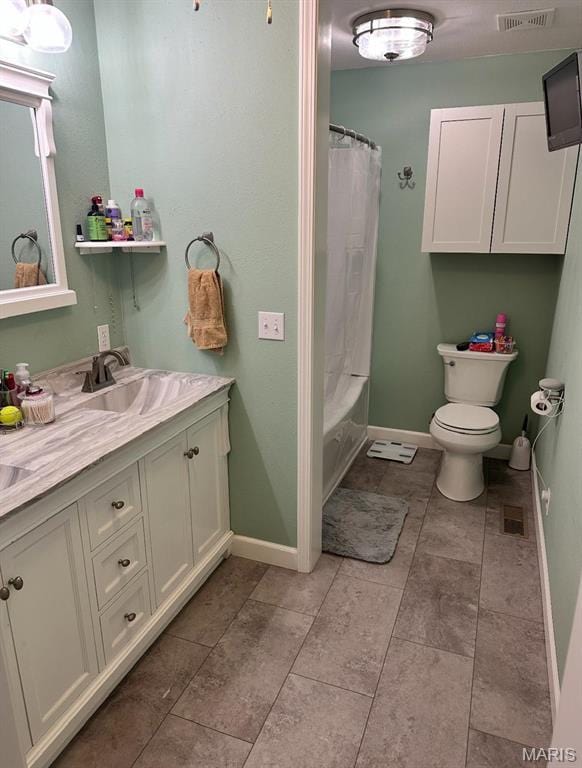 bathroom featuring baseboards, toilet, vanity, and tile patterned floors