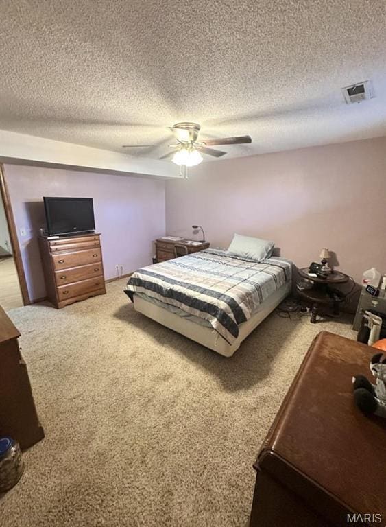 bedroom featuring light carpet, a textured ceiling, and a ceiling fan