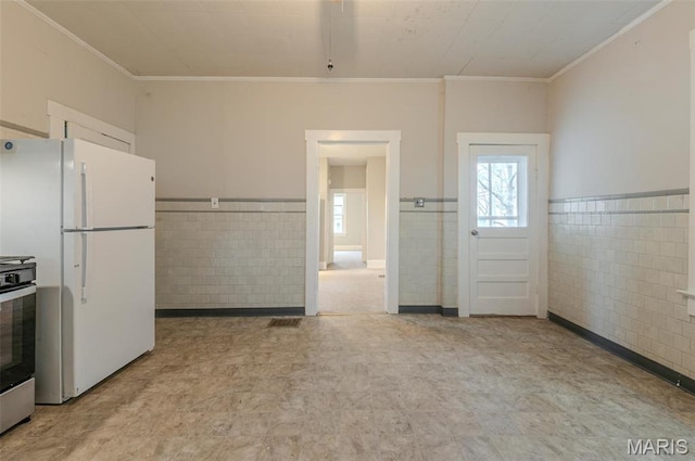 338 Horn Ave, Saint Louis, MO 63125 - kitchen featuring freestanding refrigerator, tile walls, ornamental molding, tile patterned floors, and a wainscoted wall