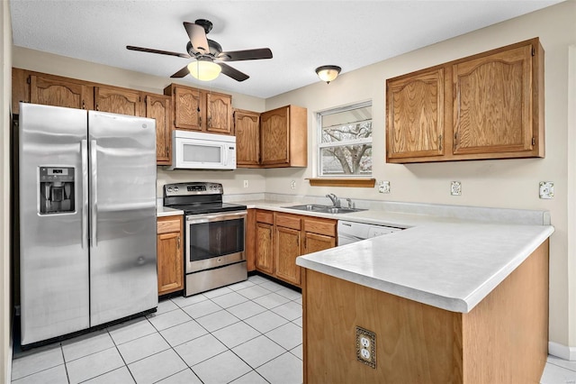 413 Oak Pl, Lake St Louis, MO 63367 - kitchen featuring appliances with stainless steel finishes, a peninsula, brown cabinets, a sink, and light countertops
