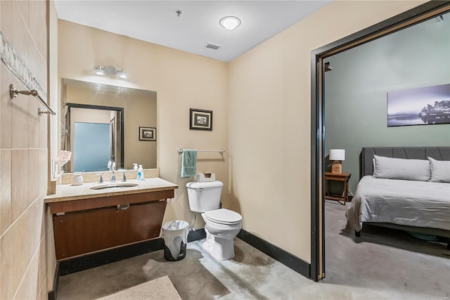 bathroom with toilet, vanity, and concrete floors