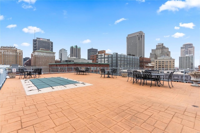view of pool featuring a view of skyline, outdoor dining space, and a patio area