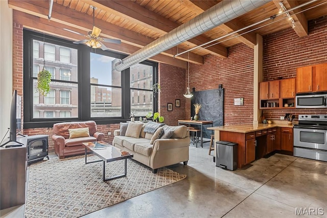 1123 Washington Ave Unit 305, Saint Louis, MO 63101 - living room with brick wall, wood ceiling with exposed beams, concrete floors, a wood stove, and a ceiling fan