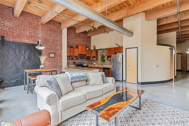 1123 Washington Ave Unit 305, Saint Louis, MO 63101 - living area with wooden ceiling with exposed beams, concrete floors, a high ceiling, brick wall, and baseboards