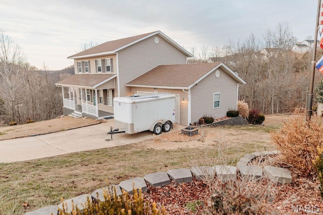 17145 Lensman Rd, Saint Robert, MO 65584 - view of property exterior with a porch, a shingled roof, an attached garage, a lawn, and concrete driveway