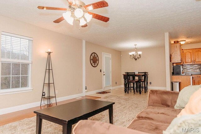 17145 Lensman Rd, Saint Robert, MO 65584 - living room with a chandelier, plenty of natural light, baseboards, and a textured ceiling