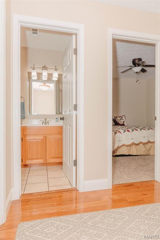 17145 Lensman Rd, Saint Robert, MO 65584 - bathroom featuring wood finished floors, vanity, baseboards, and a ceiling fan