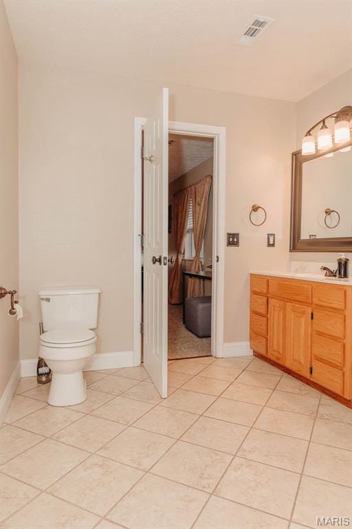 17145 Lensman Rd, Saint Robert, MO 65584 - bathroom with tile patterned flooring, toilet, vanity, and baseboards